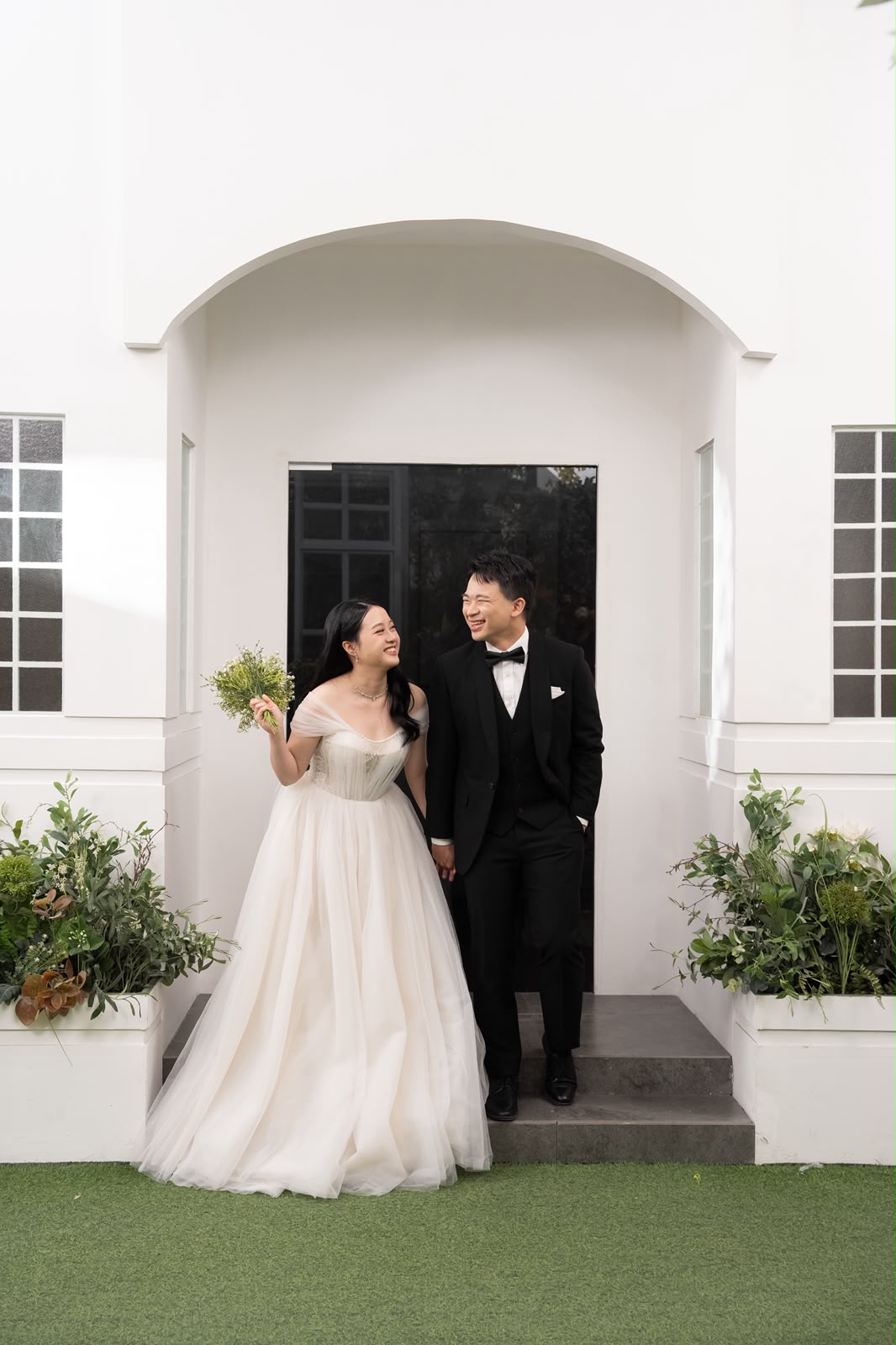 Kelwin and Christy at a white archway