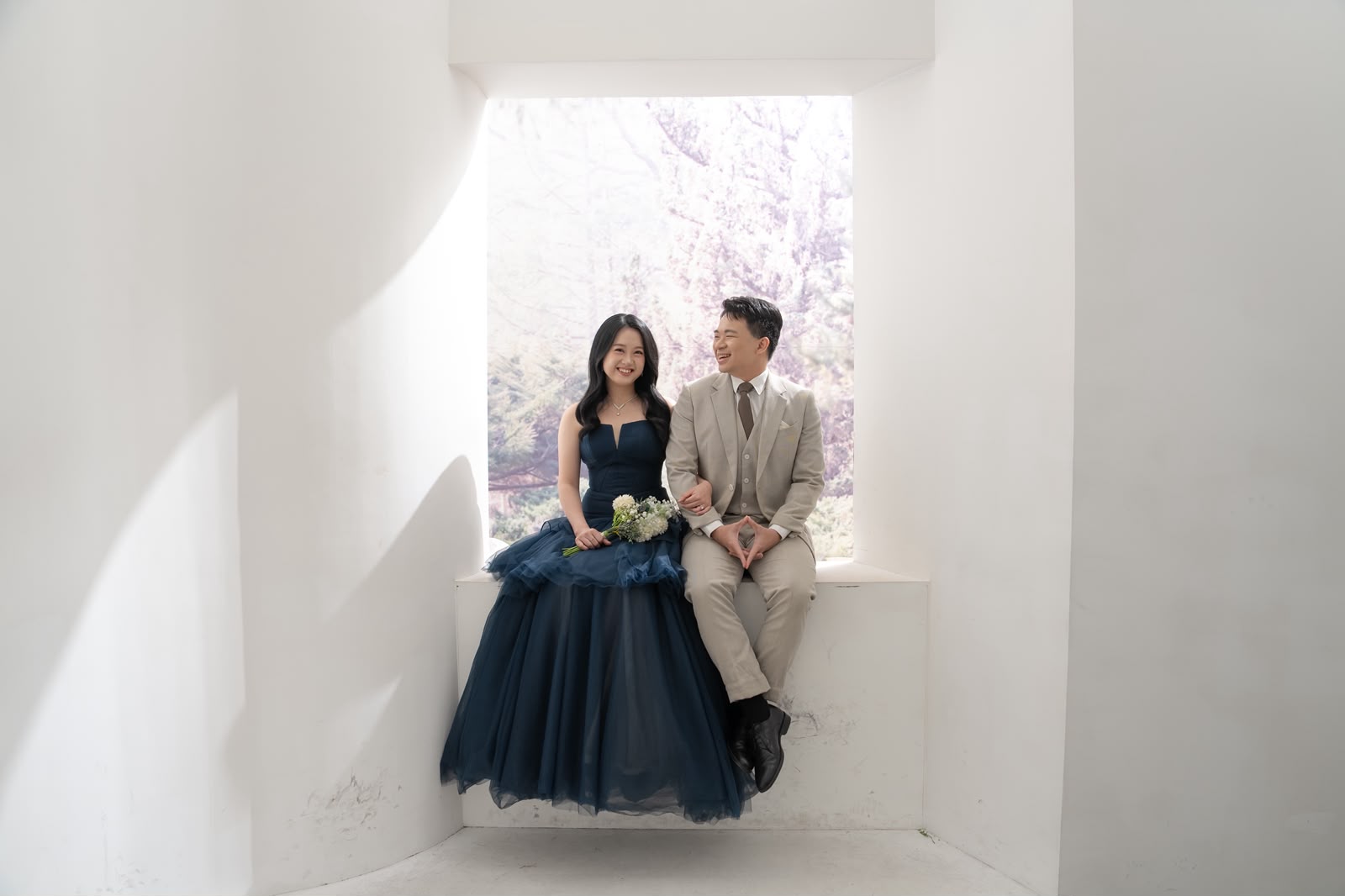 Kelwin and Christy resting in a bright window nook