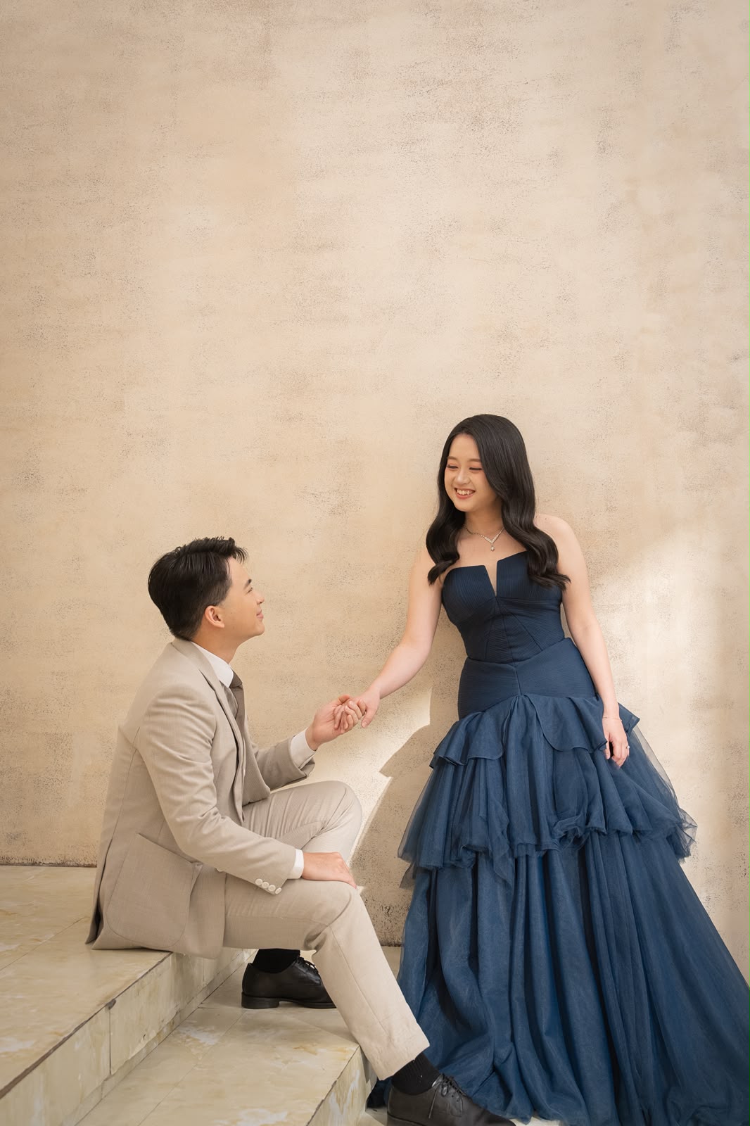 Kelwin kneeling to hold Christy's hand