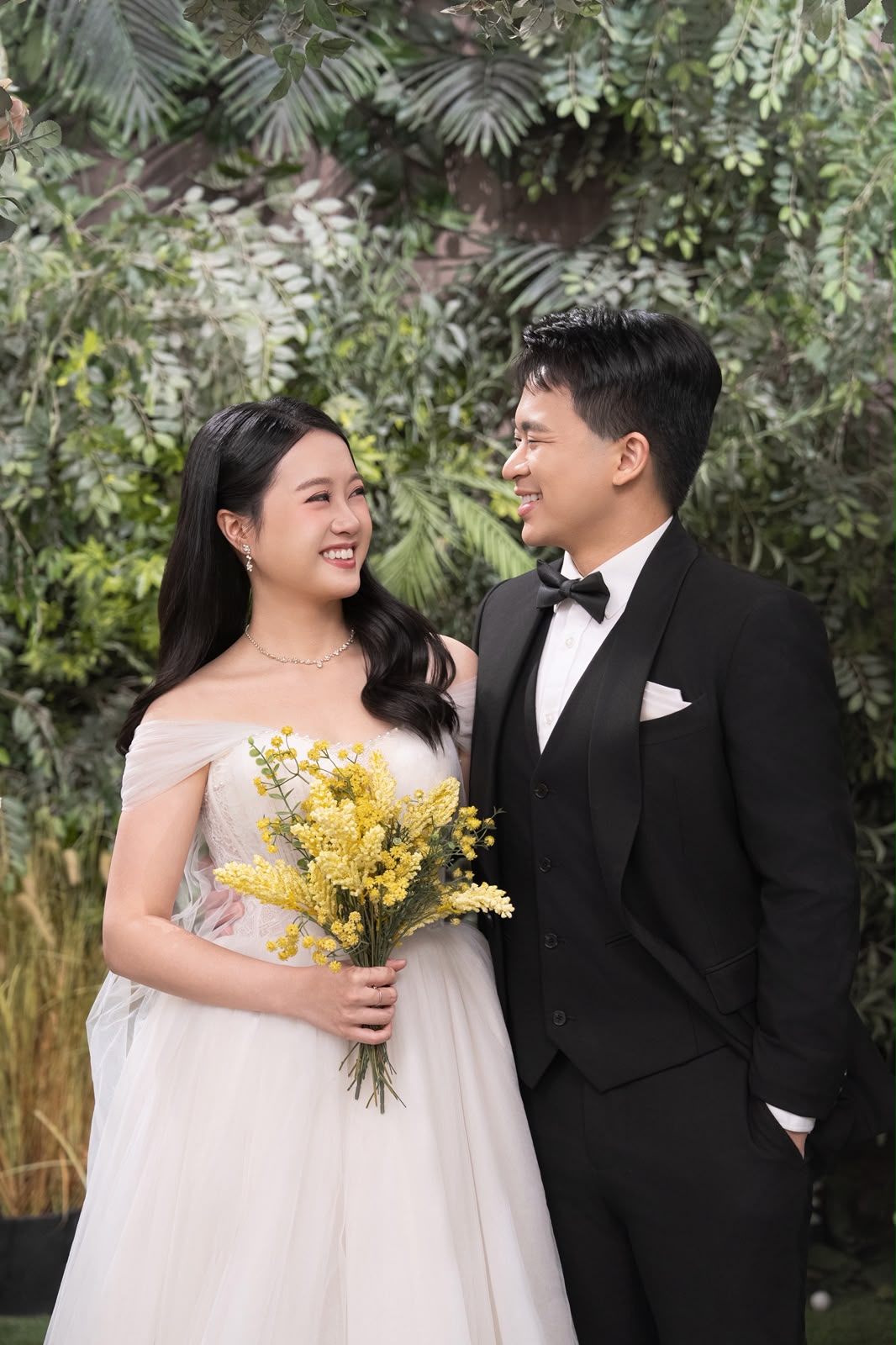 Kelwin and Christy laughing with a yellow bouquet